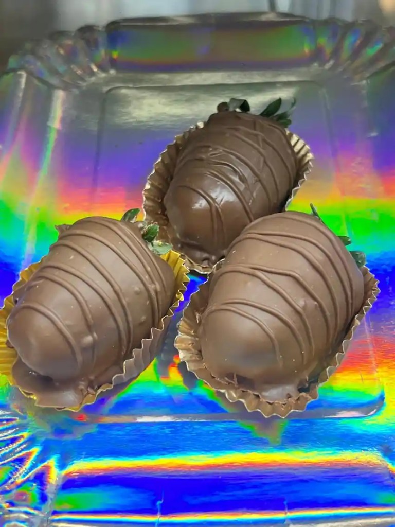 Morangos do Nordeste cobertos com chocolate ao leite em forminhas douradas