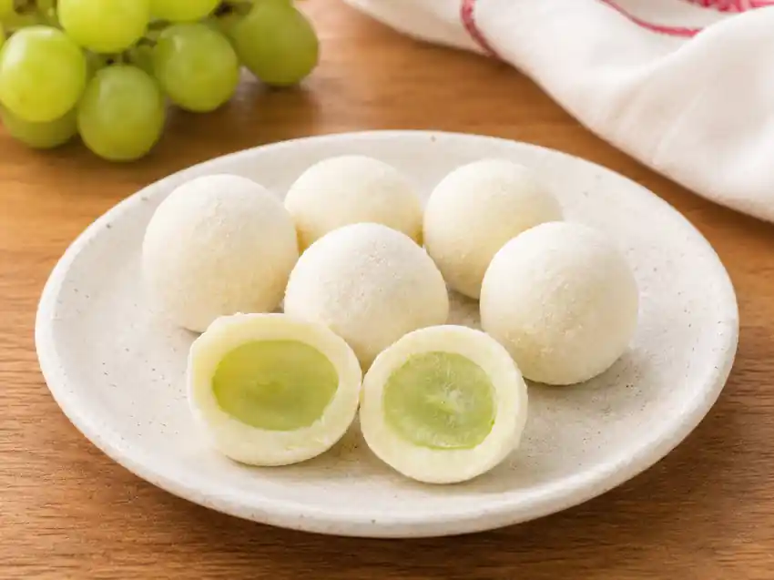 Surpresa de Uva com uva verde envolvida em brigadeiro branco em prato de cerâmica — Casa do Brigadeiro